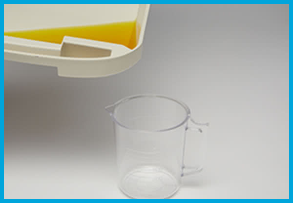 ニャンともの引き出し部にある注ぎ口から、計量できる容器等に移し替える様子