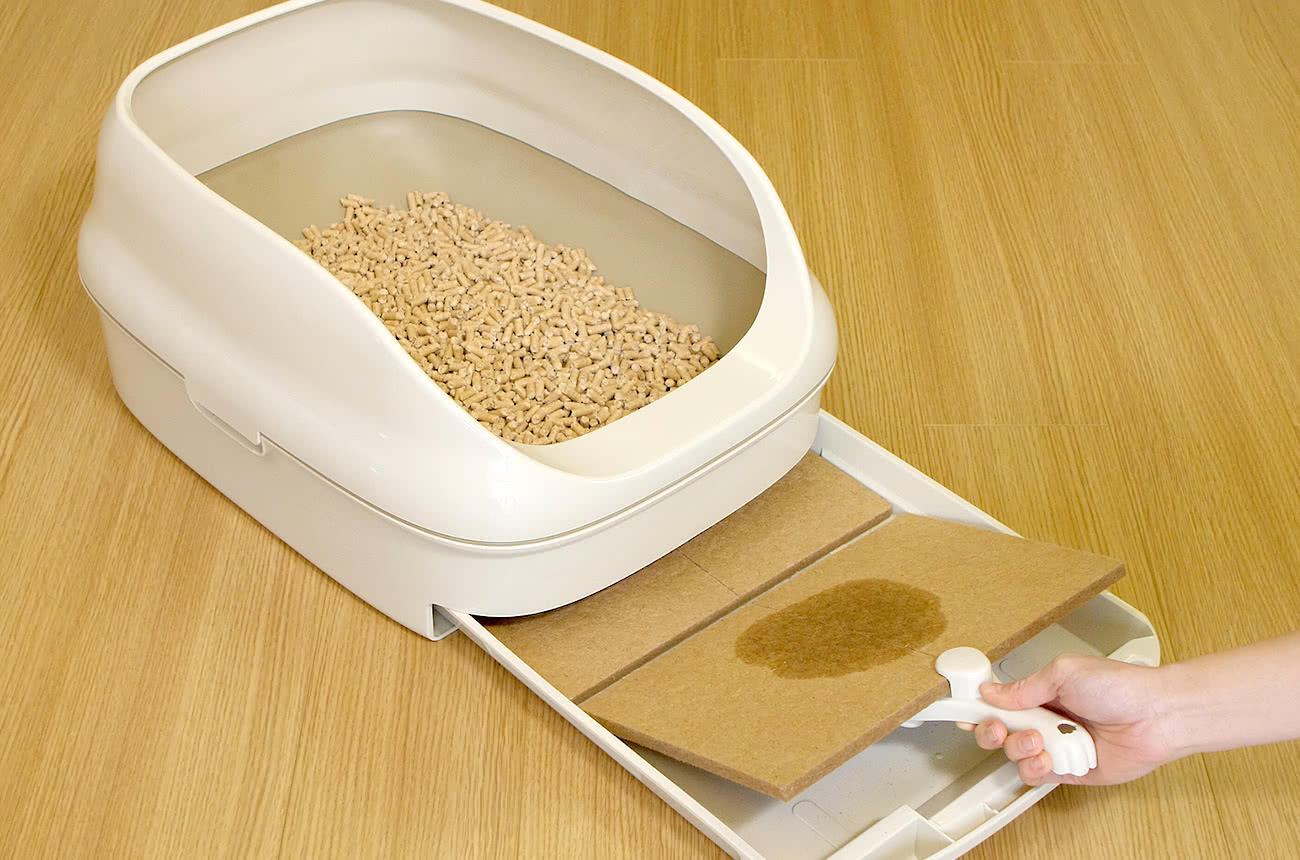 使用済みマットを専用スコップで取り出す様子